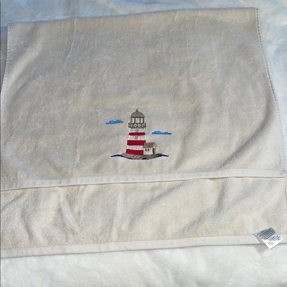 Essential Home light cream-colored bathroom towel with lighthouse appliqué